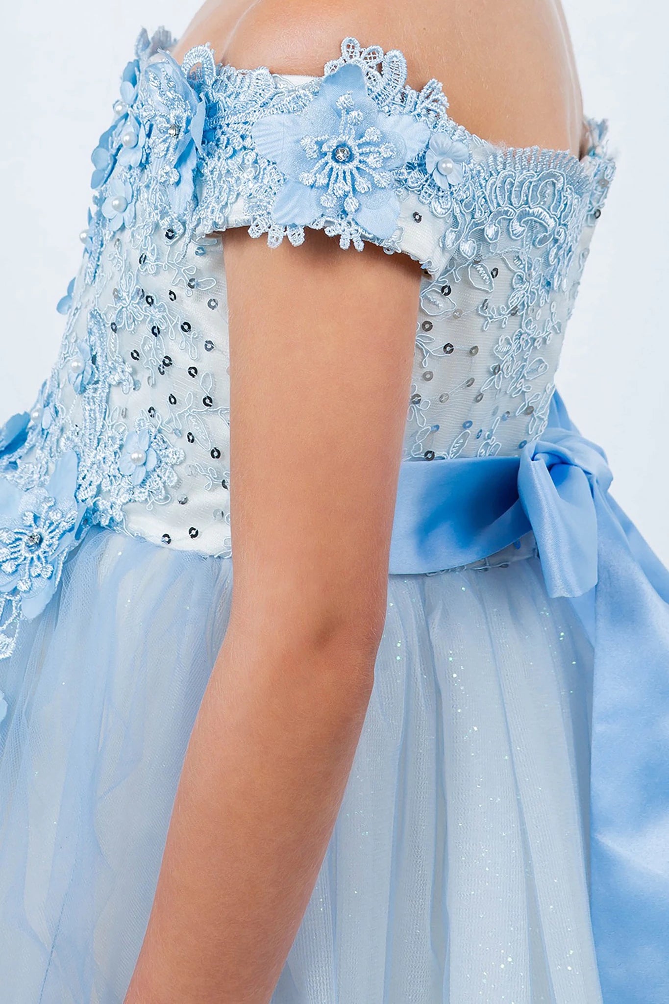 Close-up of a light blue flower girl dress with floral lace details.