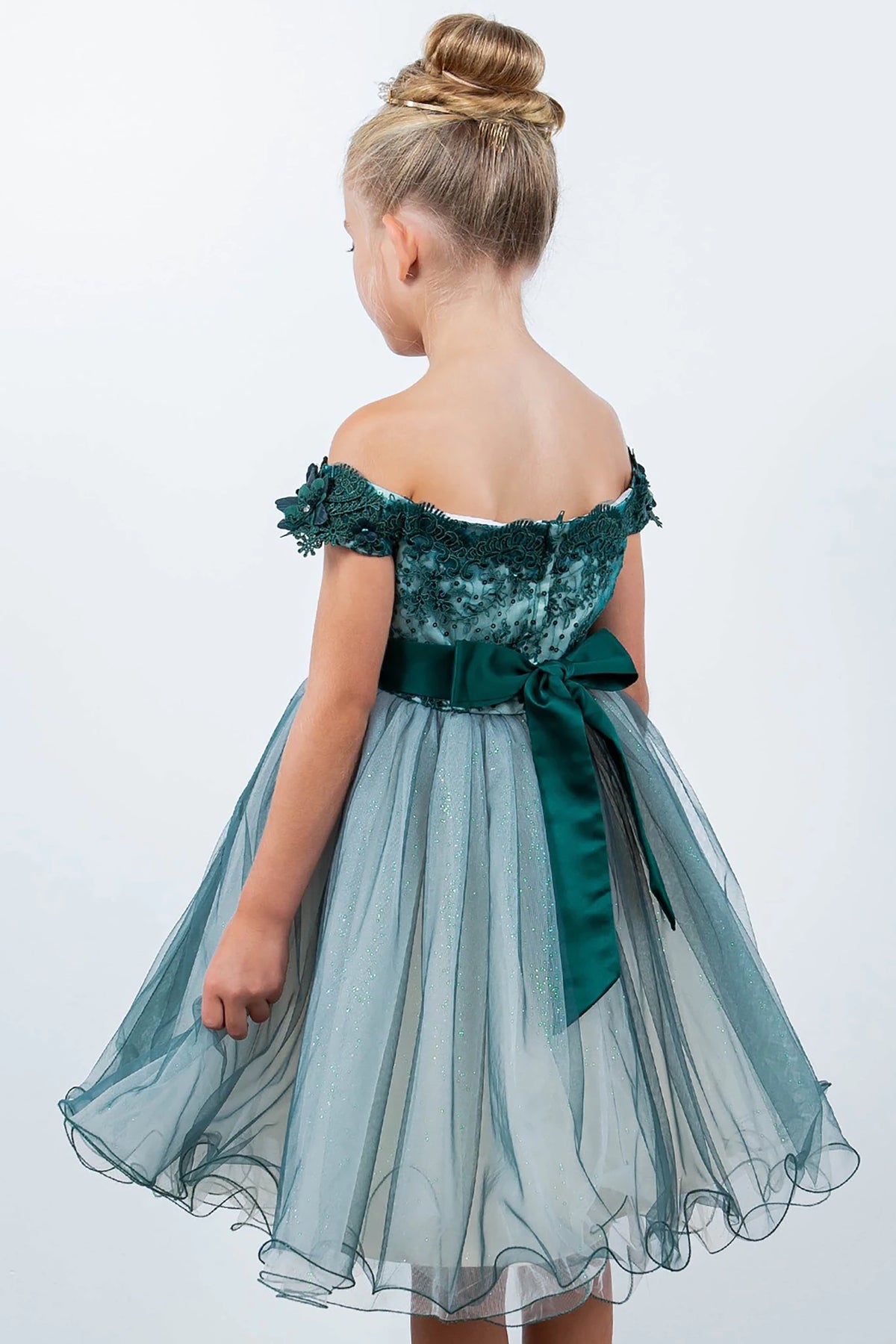 A green off-shoulder flower girl dress with a bow.