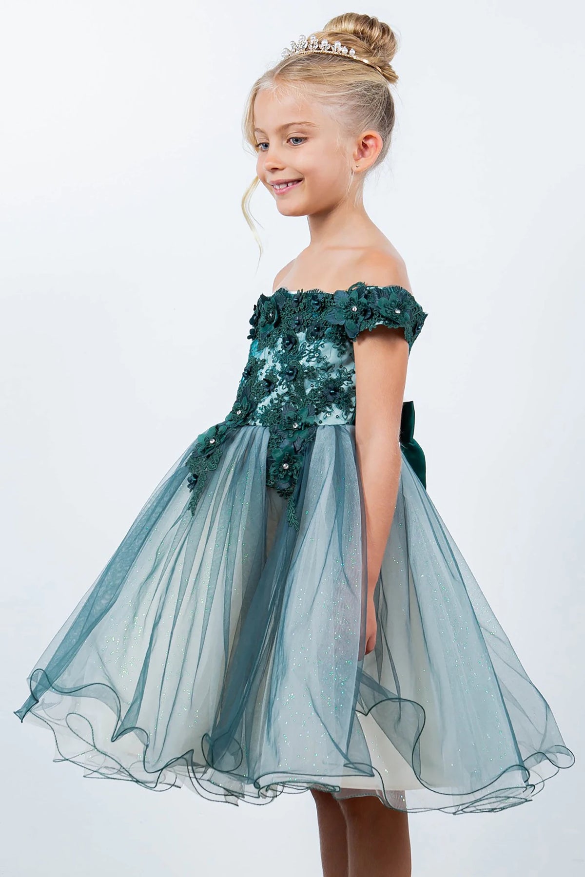 A green off-shoulder flower girl dress with floral details.