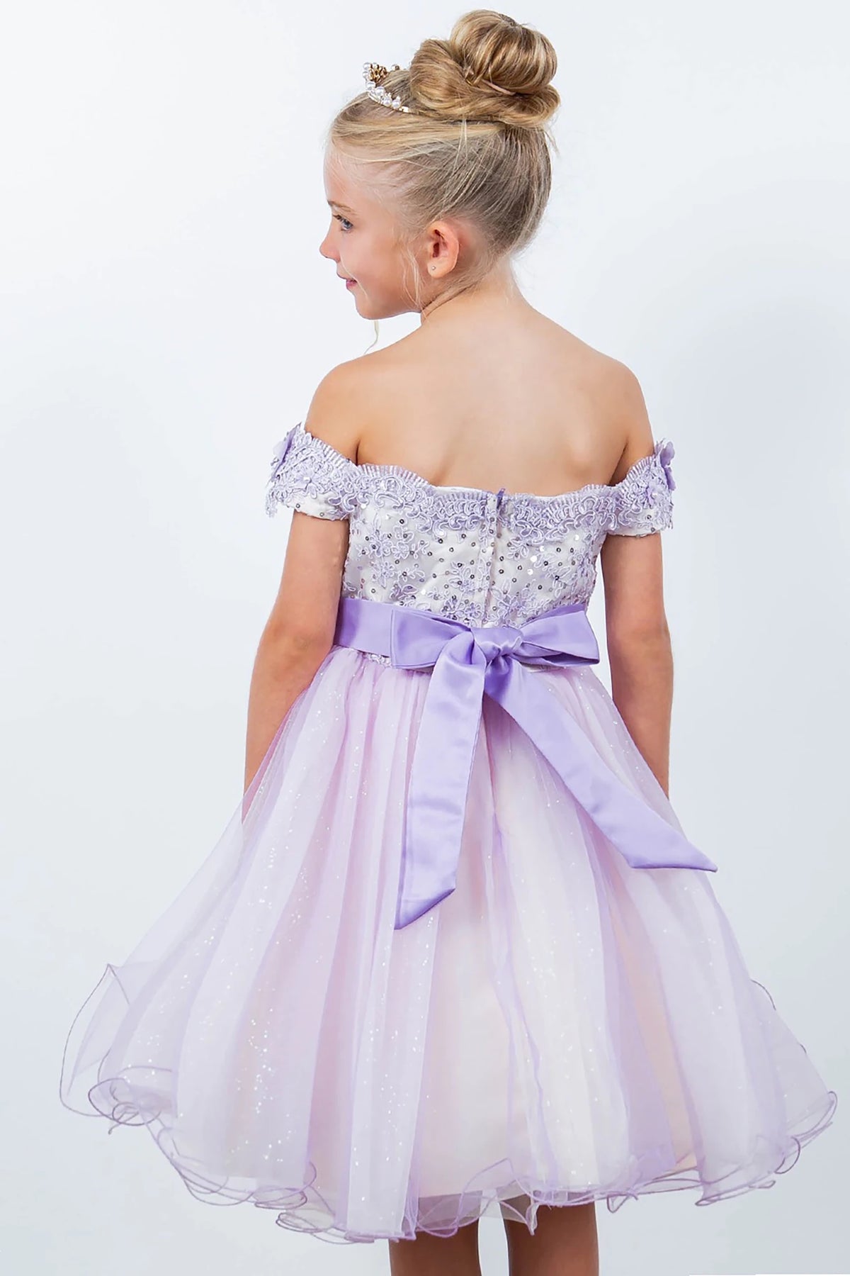 A lilac off-shoulder flower girl dress with a bow.