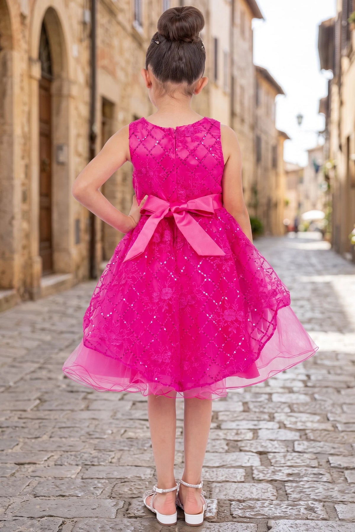 Finished details of a floral back bodice distinguish the Fuchsia kids party dress.