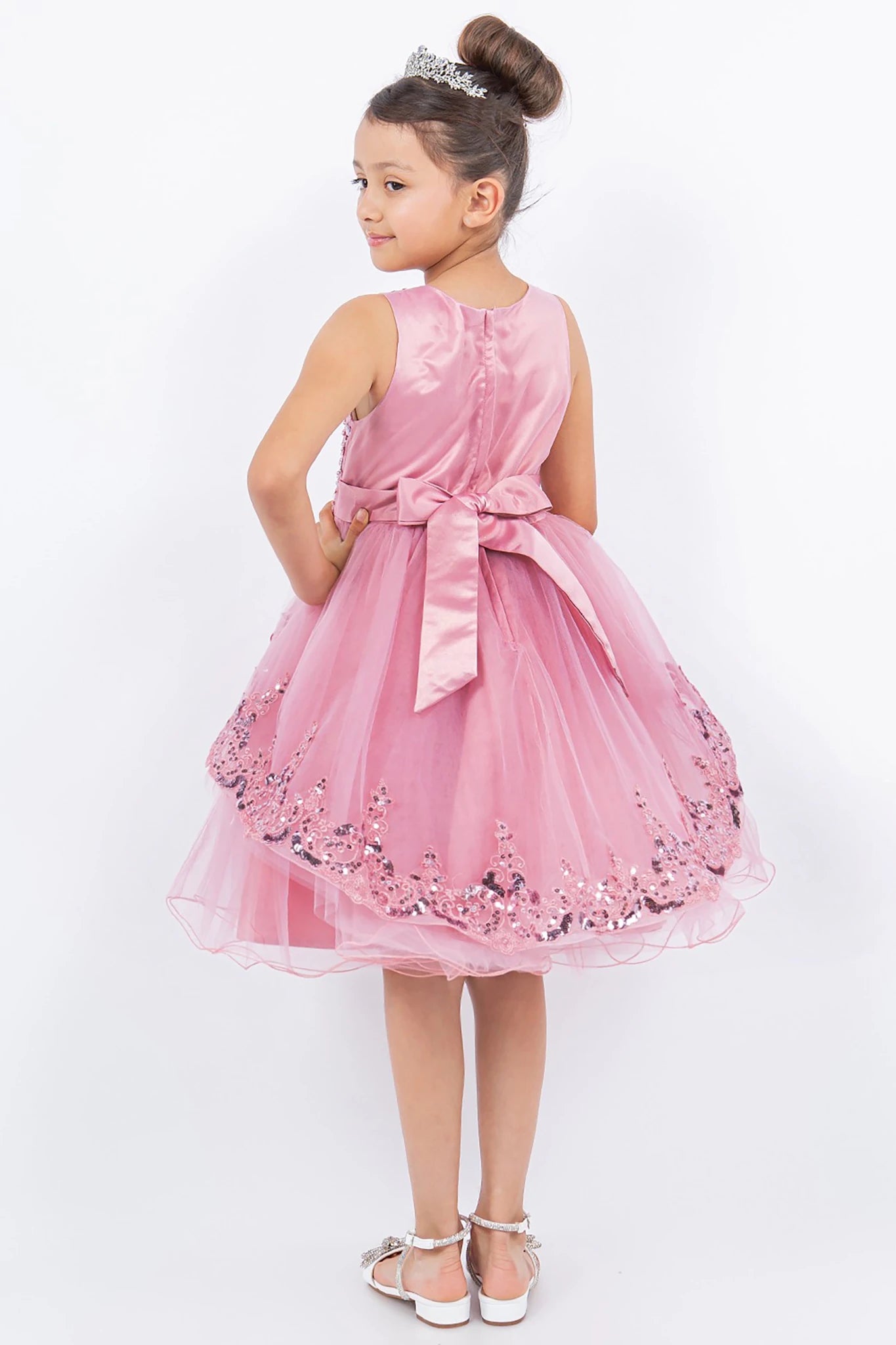 A pink flower girl dress with floral embellishments.