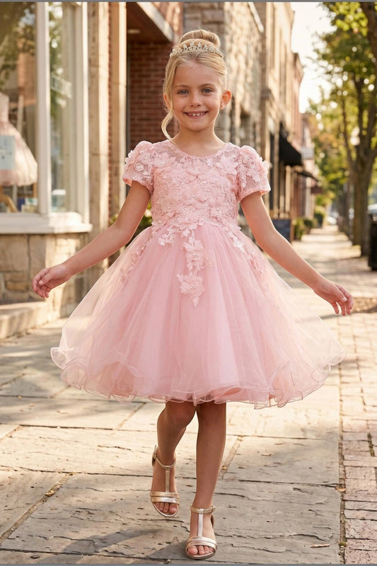 Shown in a front view, the Peach Blush flower girl dress has floral cap-sleeve bodice and flared tulle skirt.