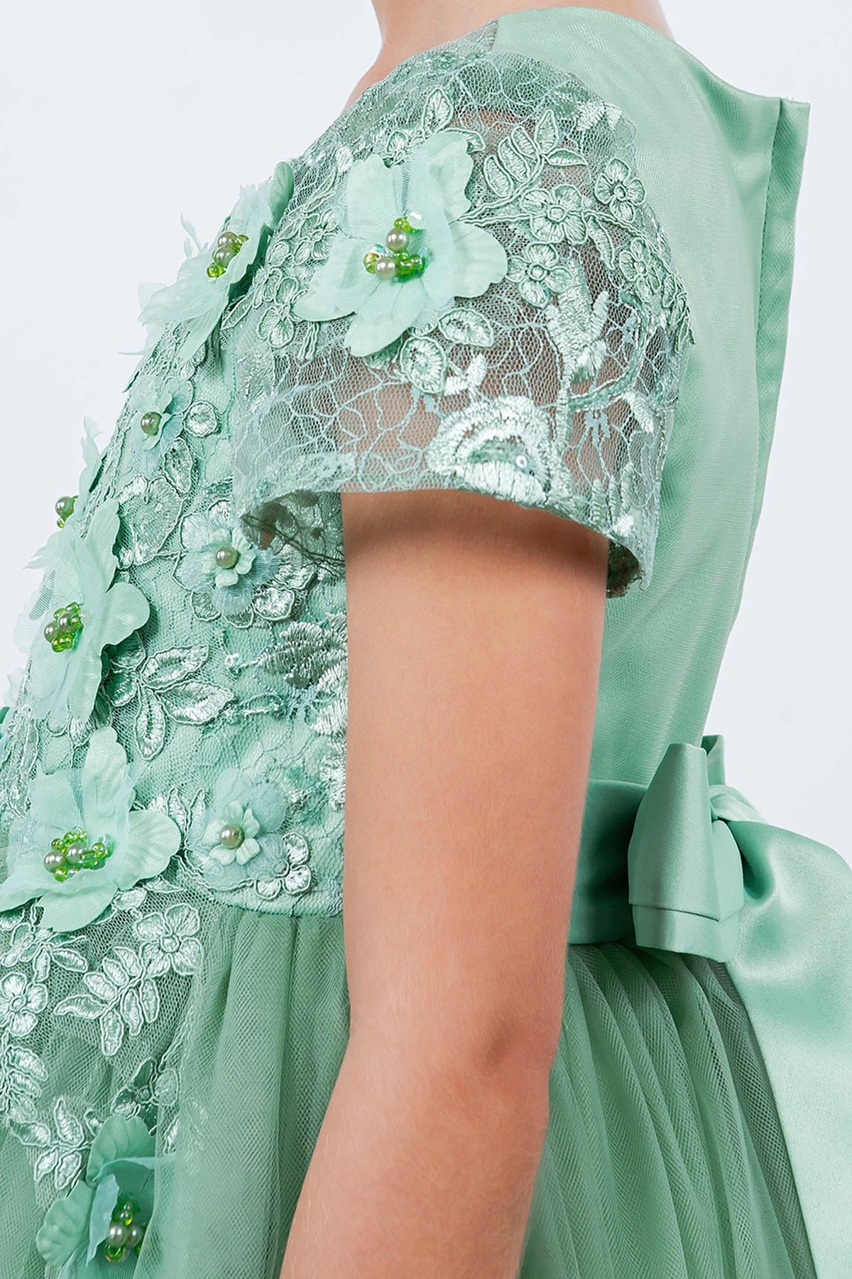 Sage flower girl dress with floral lace details.