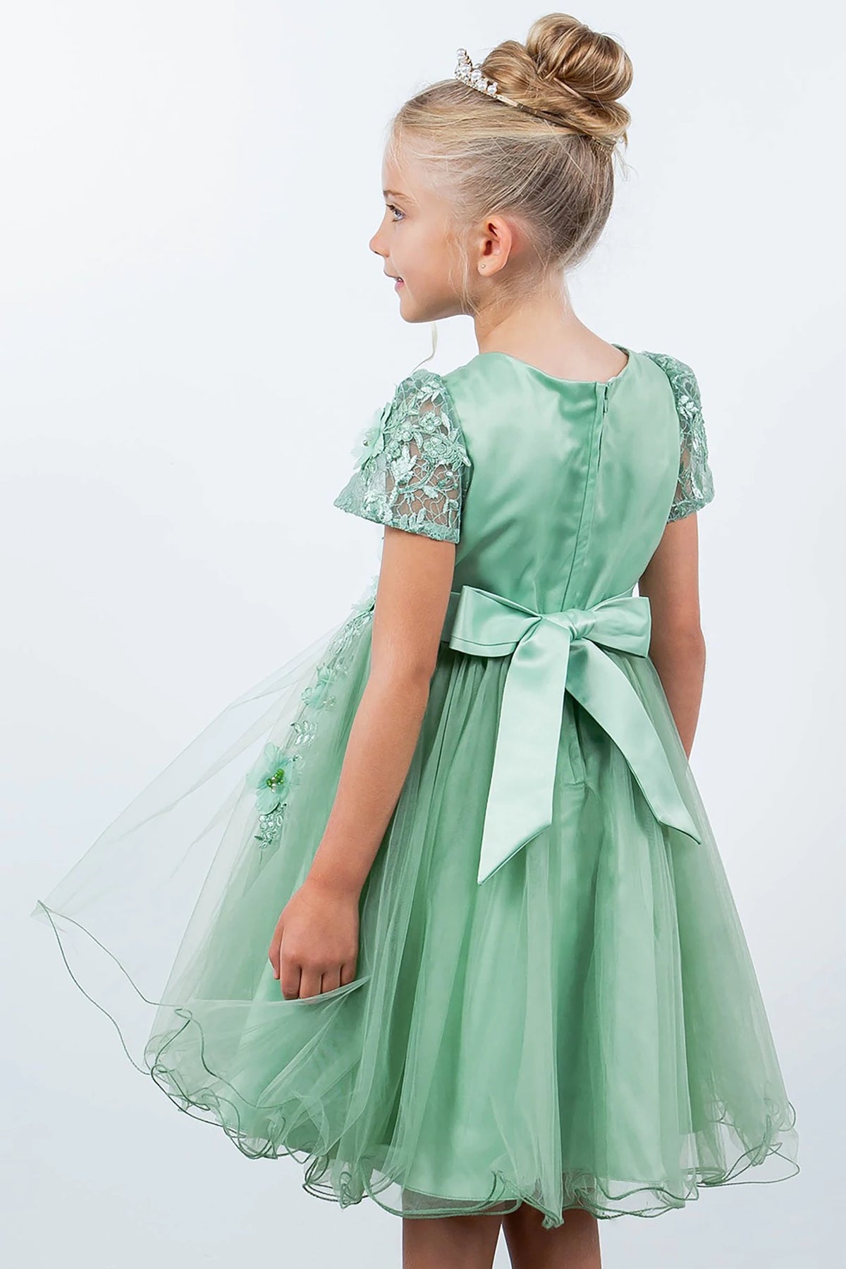 A green flower girl dress with lace sleeves and a bow.