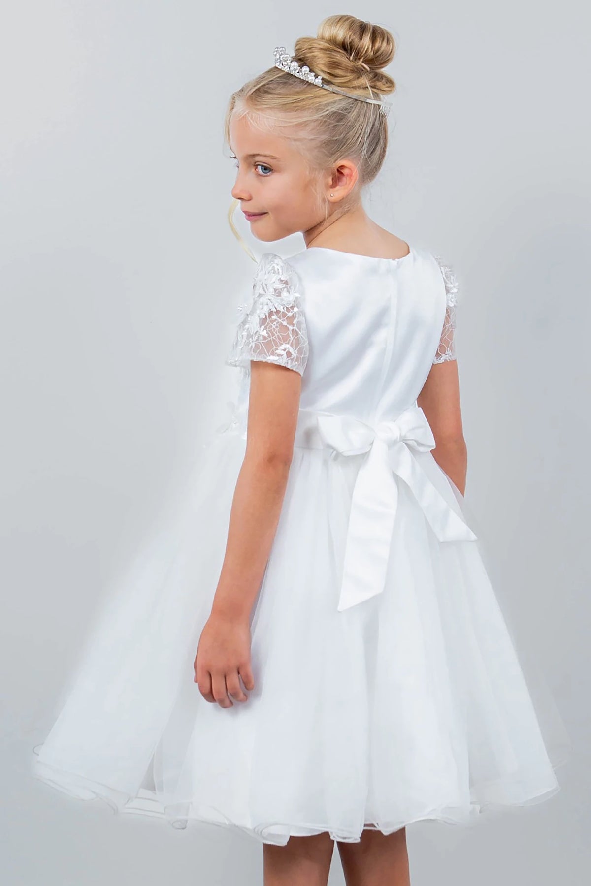 A white flower girl dress with lace sleeves.