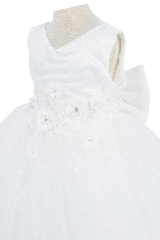 Close-up front view of white dress showing applique detail and shimmering embellishments