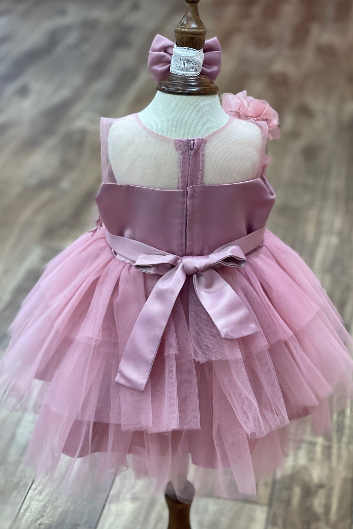 Mauve flower girl dress back view highlighting voluminous tulle skirt and elegant silhouette.