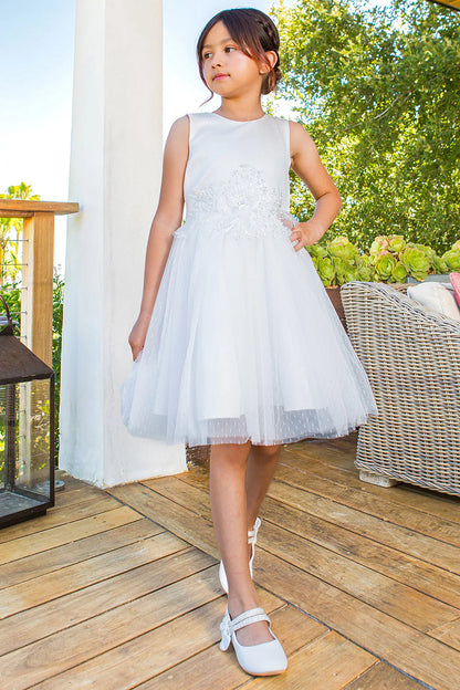 White flower girl dress features flower appliques above the layered tulle hem.