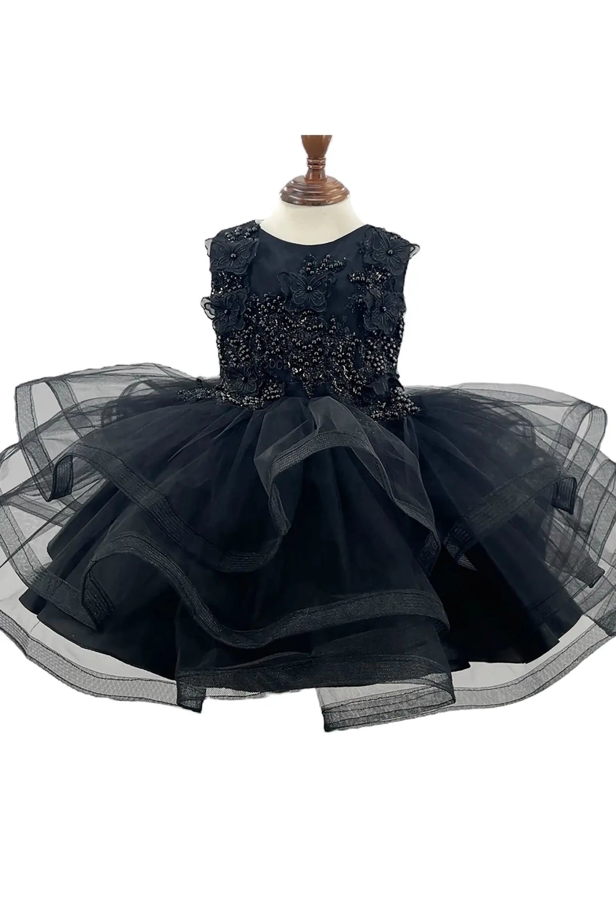 Front-facing in black multi-layered tulle 1st birthday party flower girl dress with butterfly accents and pearl embellishments on bodice.