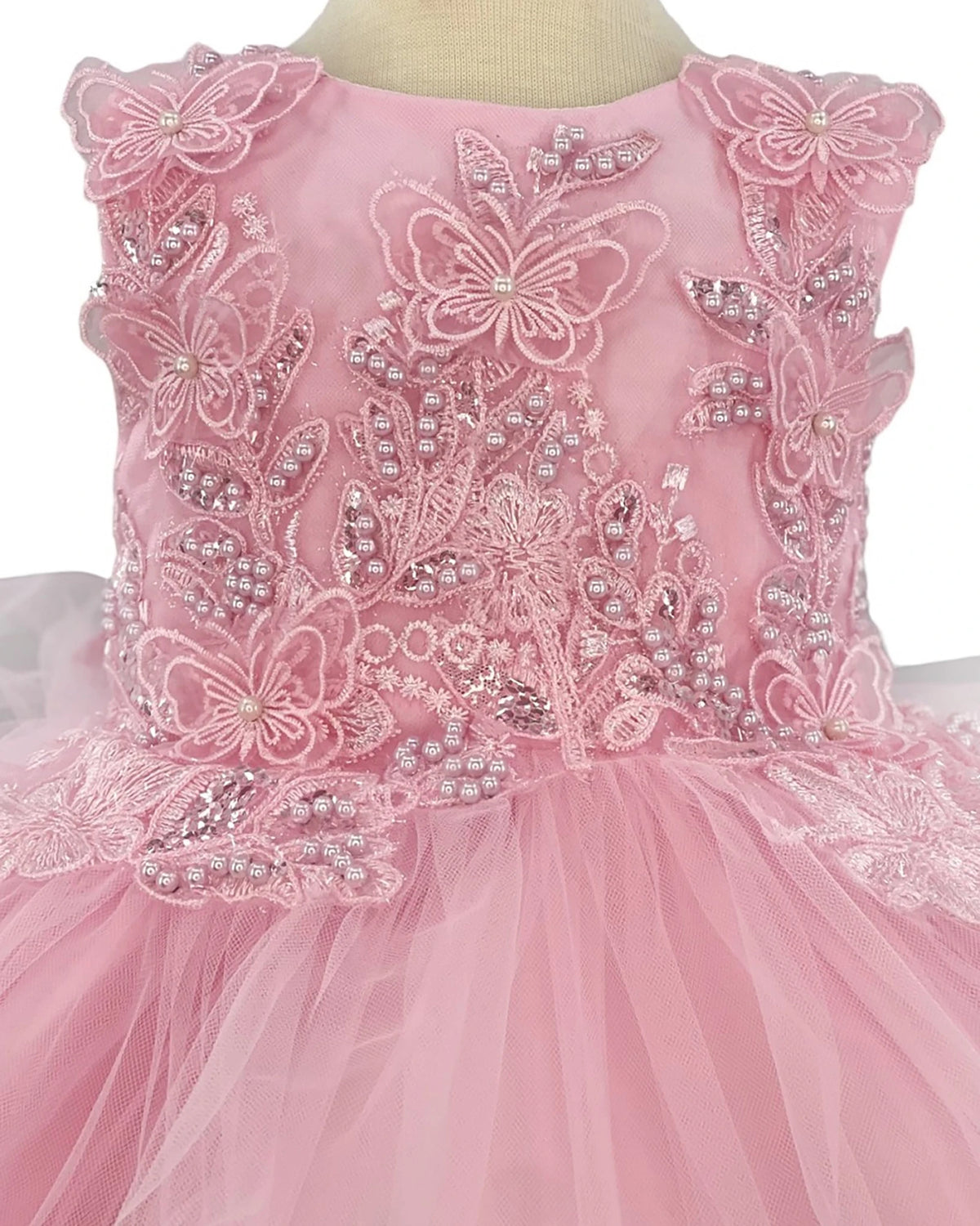 Pink flower girl dress with butterfly and floral embellishments.