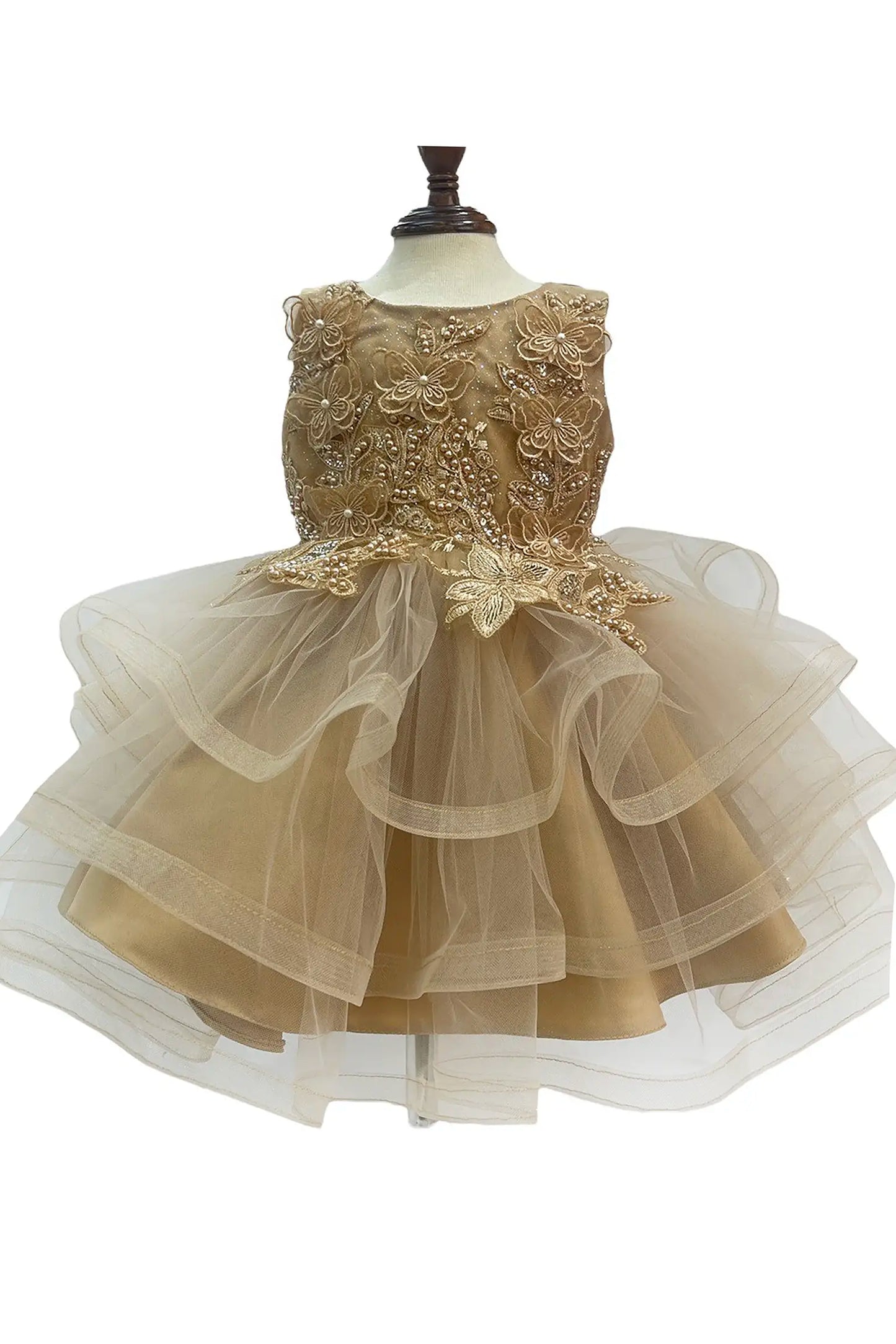 Gold dress with butterfly and floral appliques on a mannequin with a white background