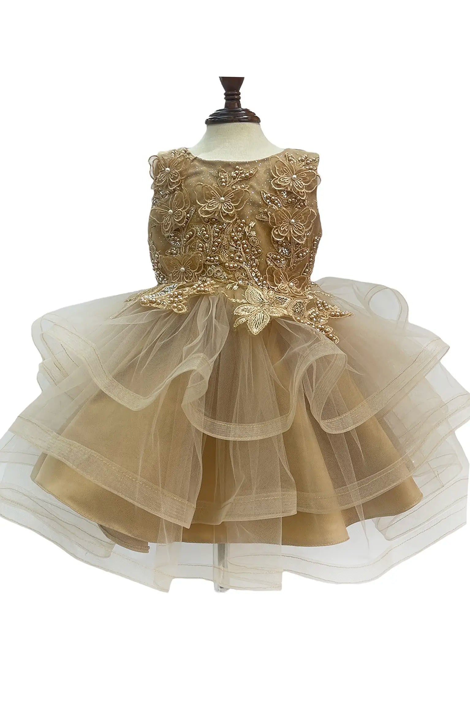 Gold dress with butterfly and floral appliques on a mannequin with a white background