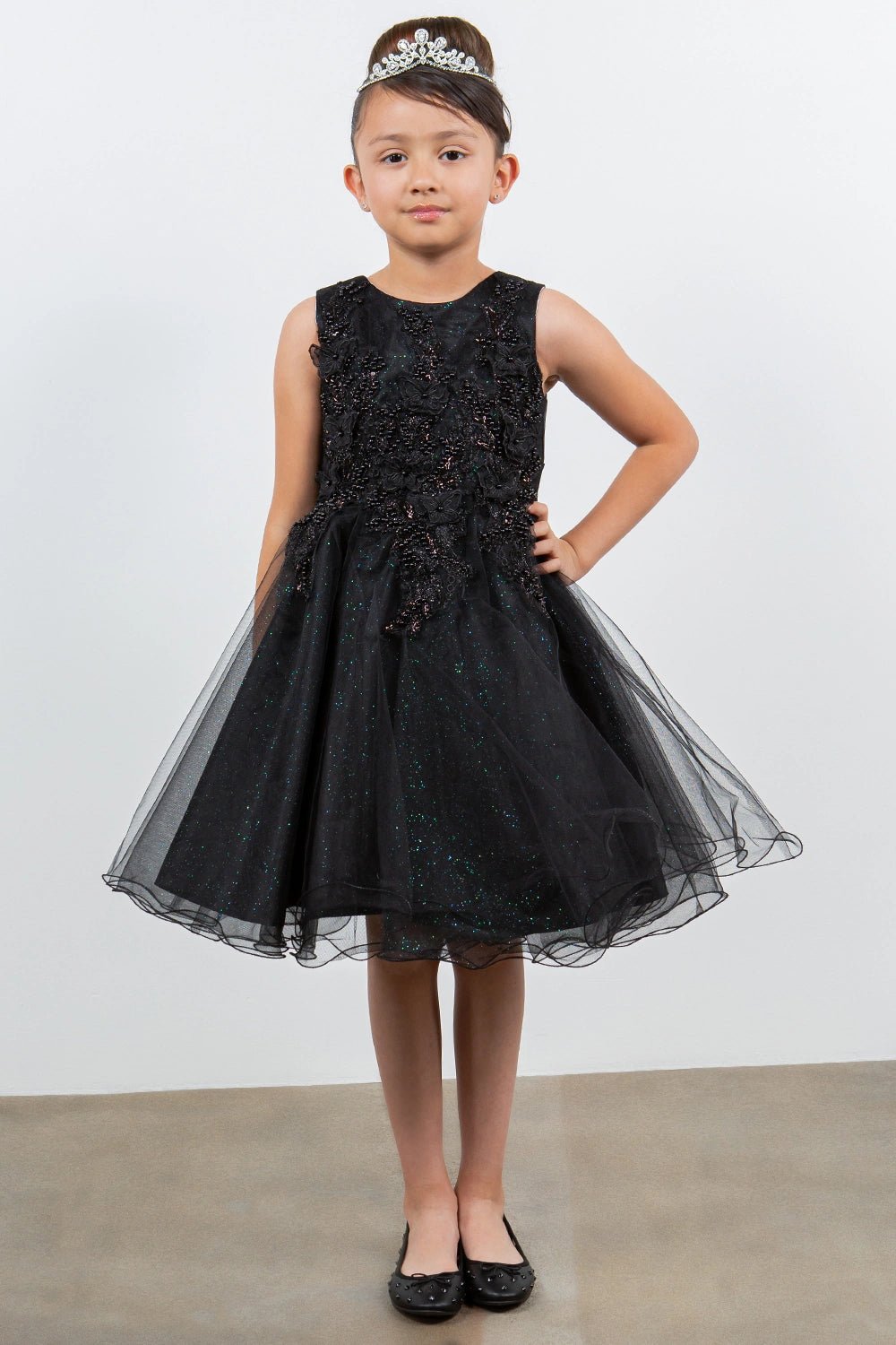 Shown in a front view, the Black flower girl dress has sleeveless floral lace bodice and short full tulle skirt.