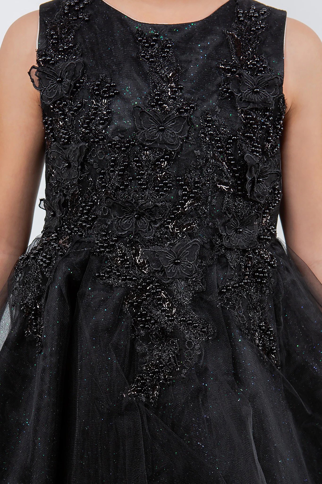Black flower girl dress with floral and butterfly patterns.