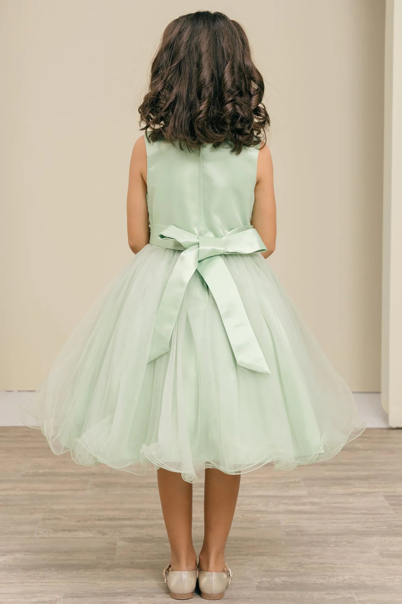A sage flower girl dress with a bow.