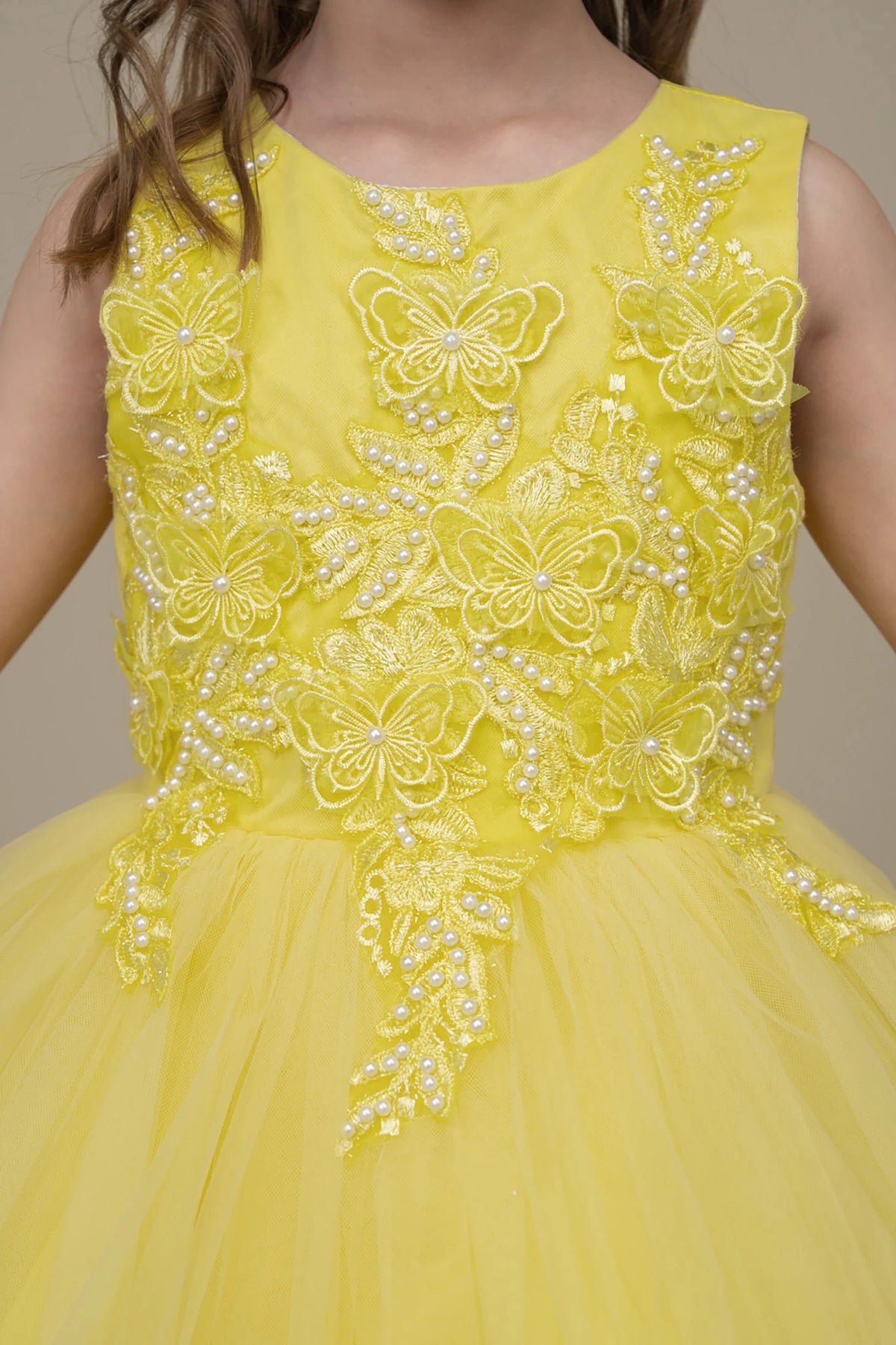 Yellow flower girl dress with butterfly and floral embellishments.