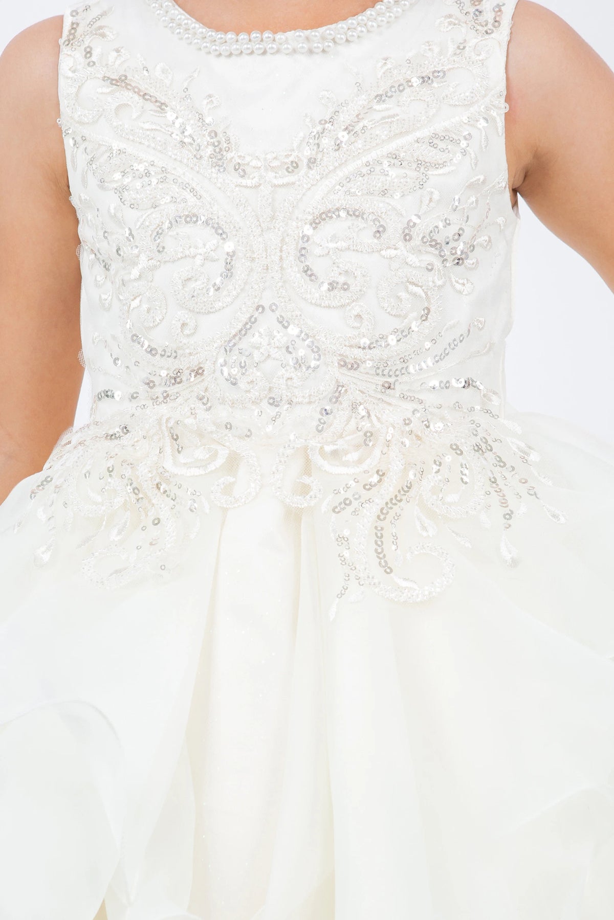 A Ivory flower girl dress showing scroll-like beading across the bodice.