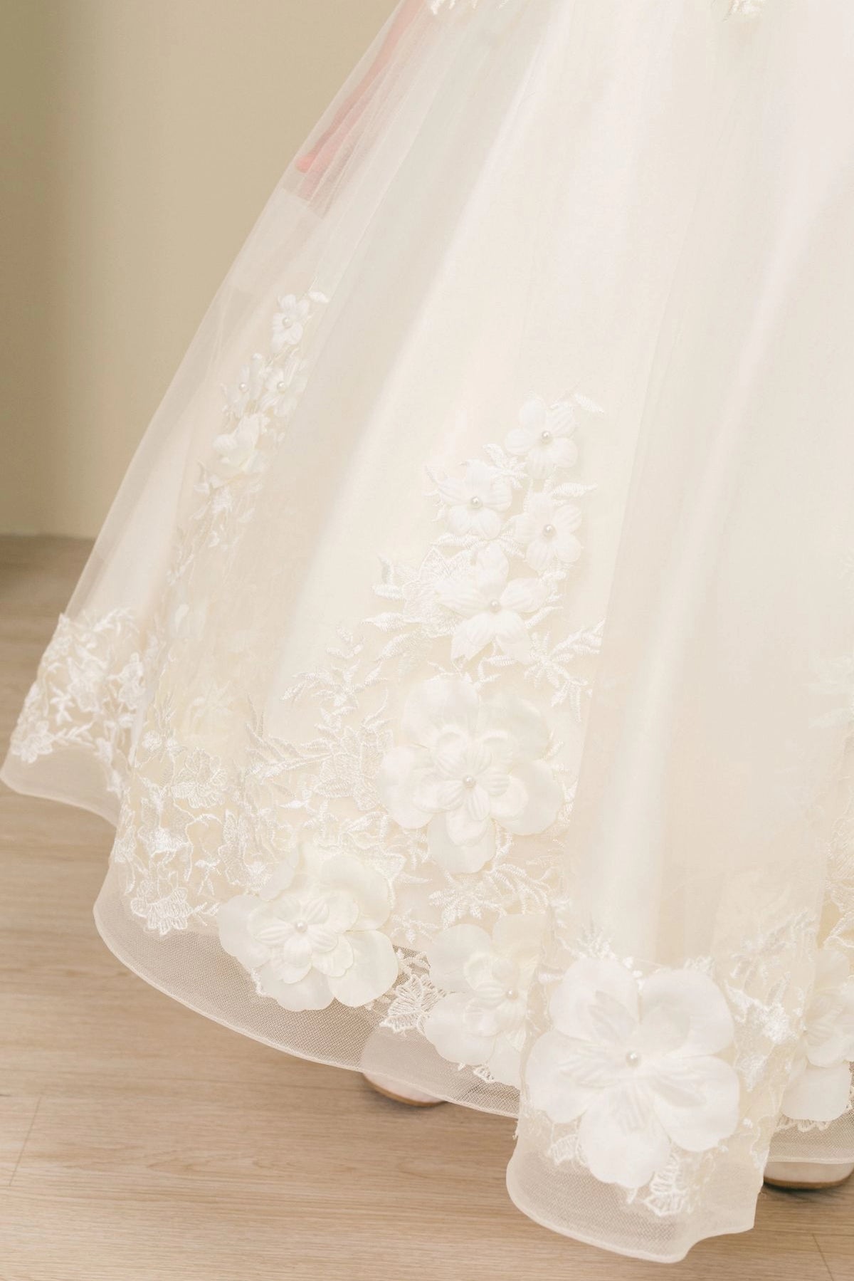 Notice the lace-trimmed skirt with raised floral appliques on this Ivory flower girl dress.