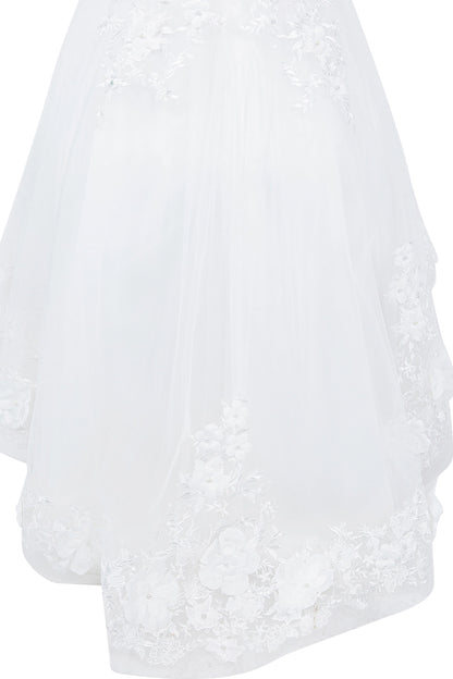 Details of the Off-White flower girl dress include scalloped lace hem beneath a tulle skirt.