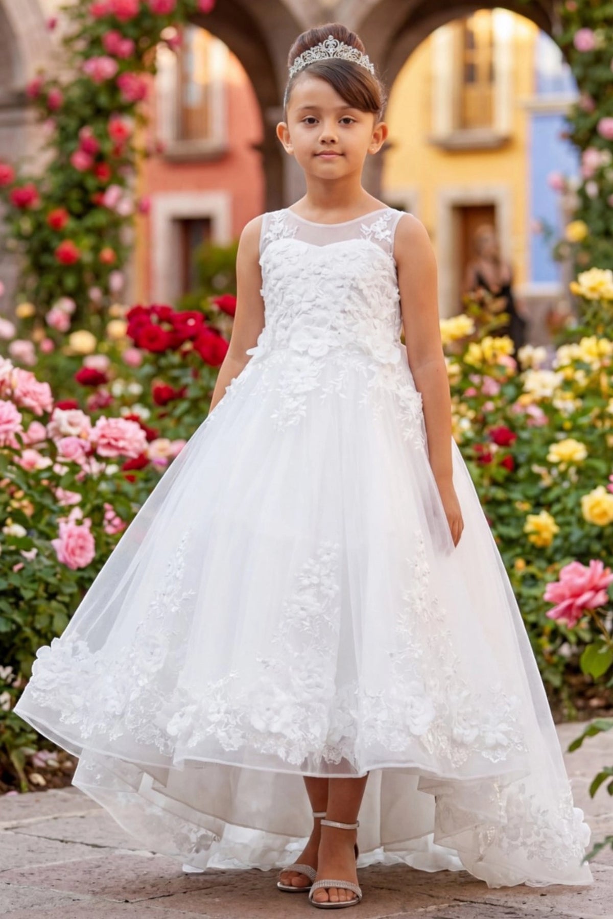 Off-White flower girl dress features floral lace across the bodice and long skirt.