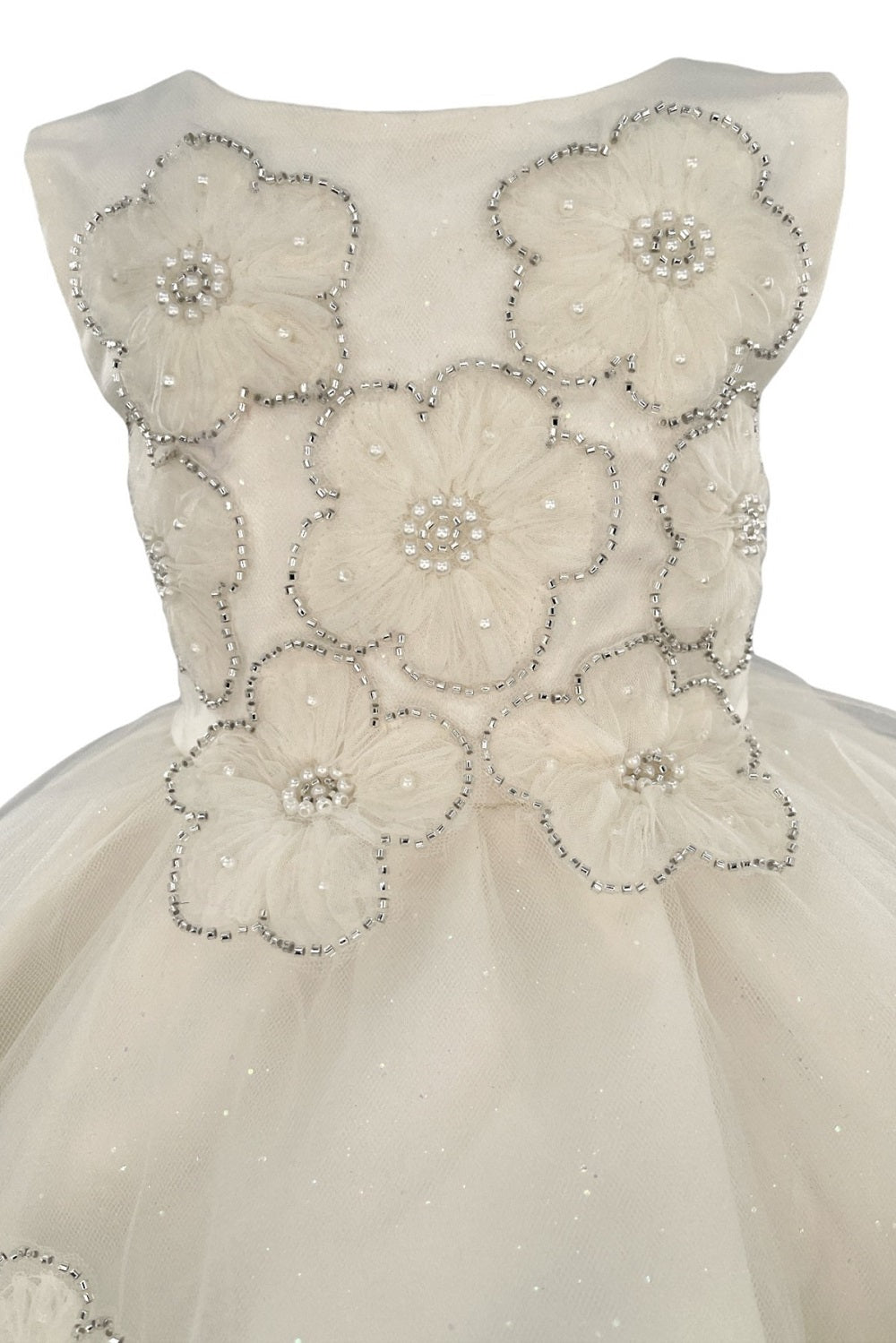 Close-up front view of ivory flower girl dress showing shimmering fabric and bow accent.