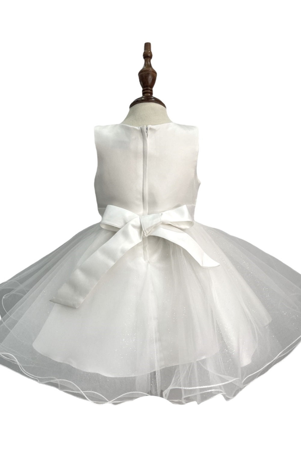 Ivory flower girl dress back view highlighting full skirt and elegant silhouette.