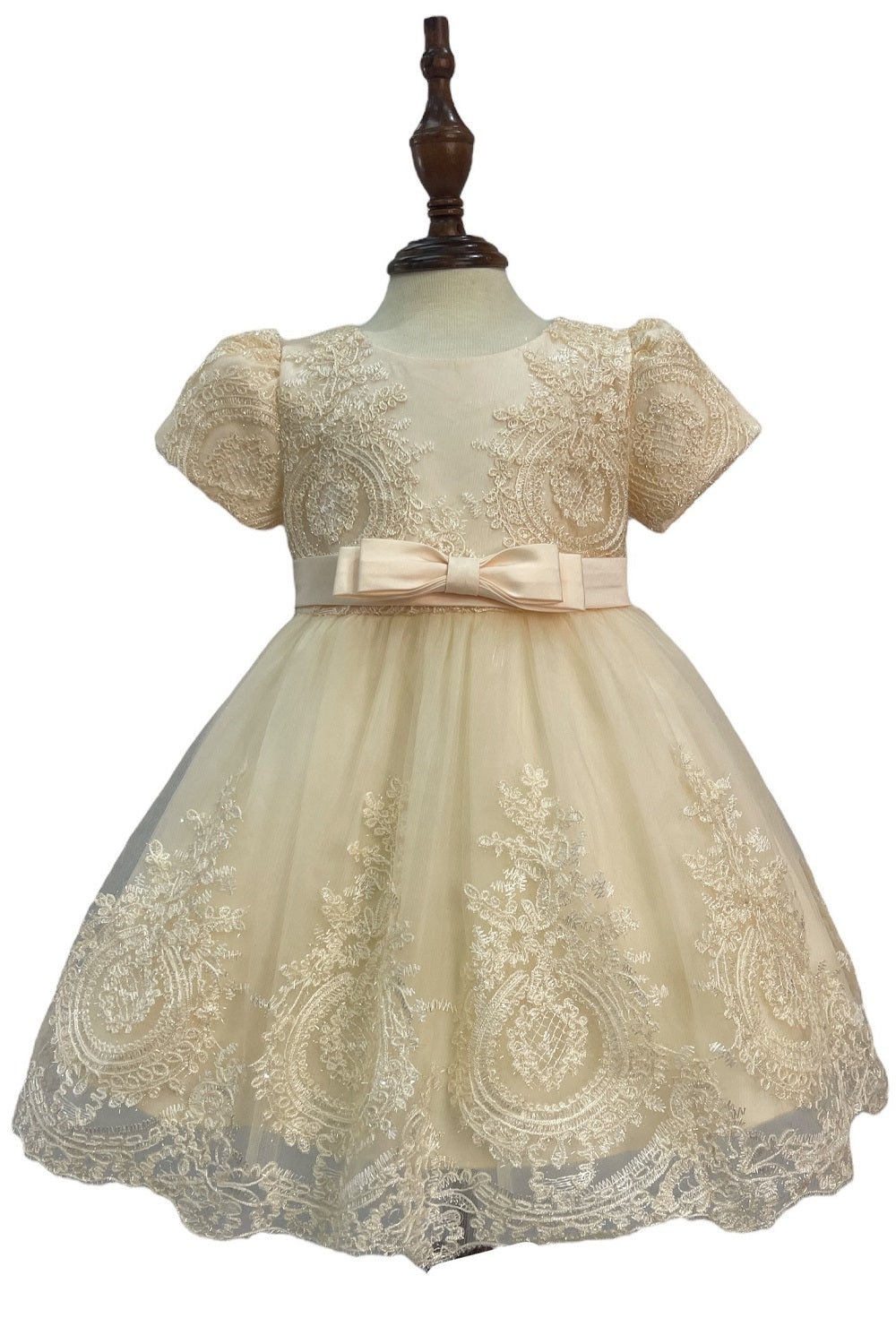 Cream flower girl dress front view with layered skirt and oversized bow detail