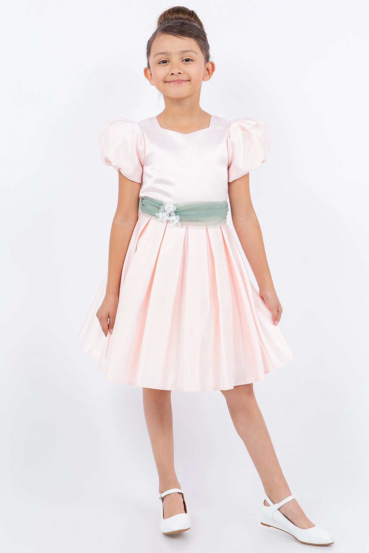 Blush flower girl dress features puff sleeves and contrasting waist sash.