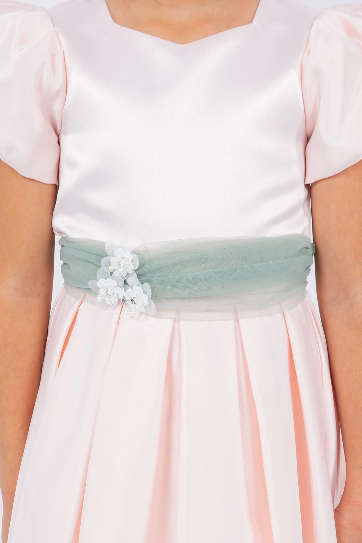 A Blush flower girl dress showing waist flower beside the contrasting sash.