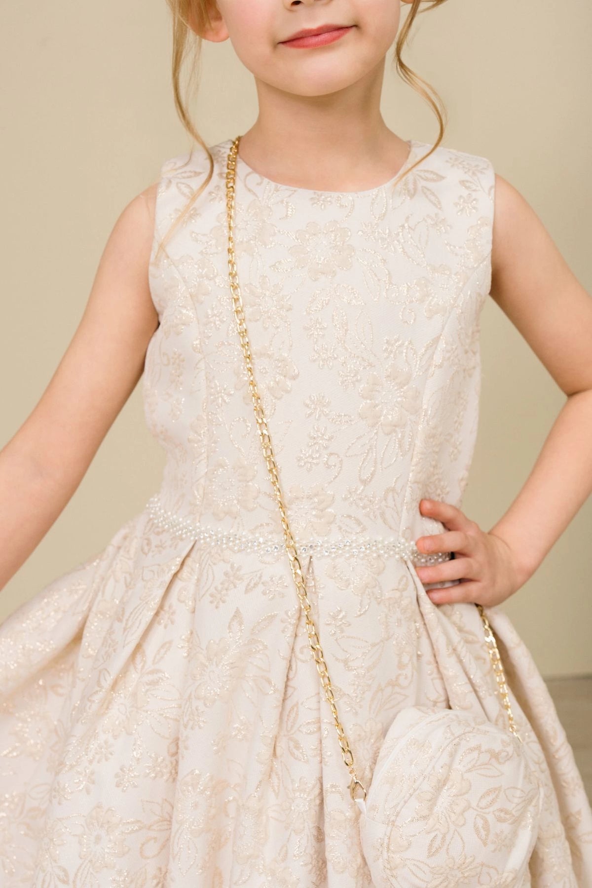 Detailed by floral jacquard texture, the Champagne kids party dress reveals its construction.