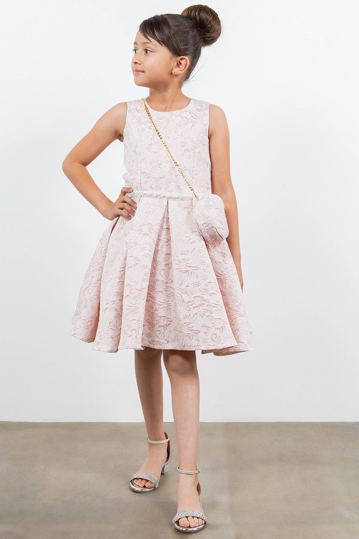 Accented a round matching purse adds character to this Pink kids party dress.