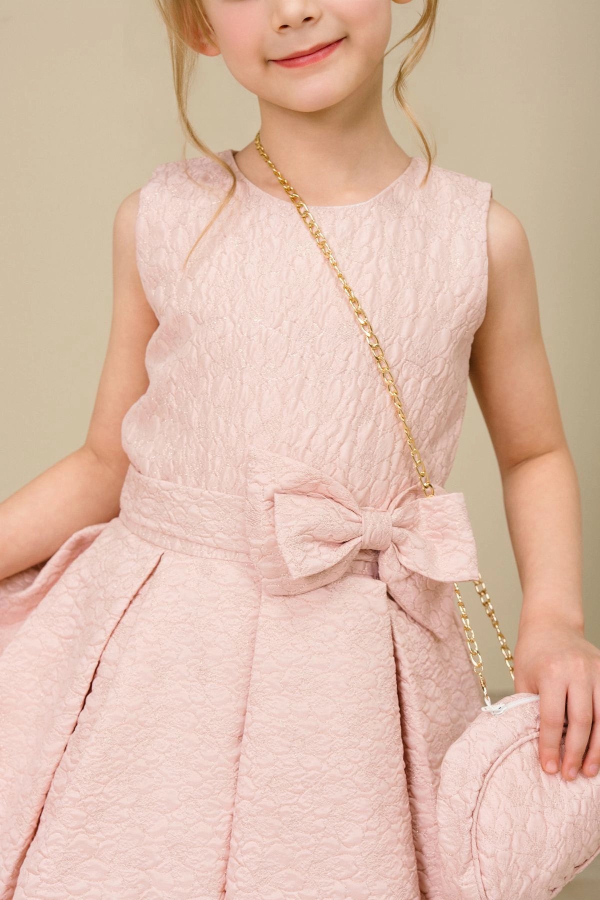 Accented a large front waist bow adds character to this Pink kids party dress.
