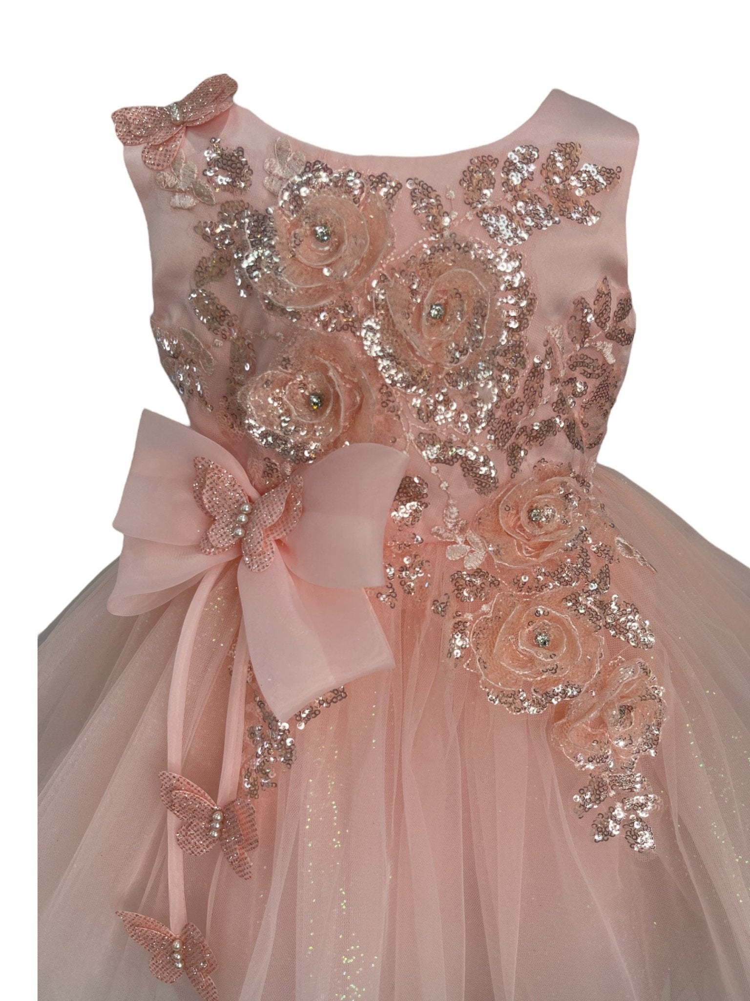 Close-up front view of blush dress showing shimmering fabric and bow accent