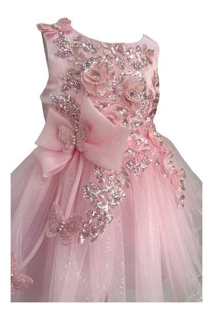 Close-up front view of pink dress showing shimmering fabric and bow accent