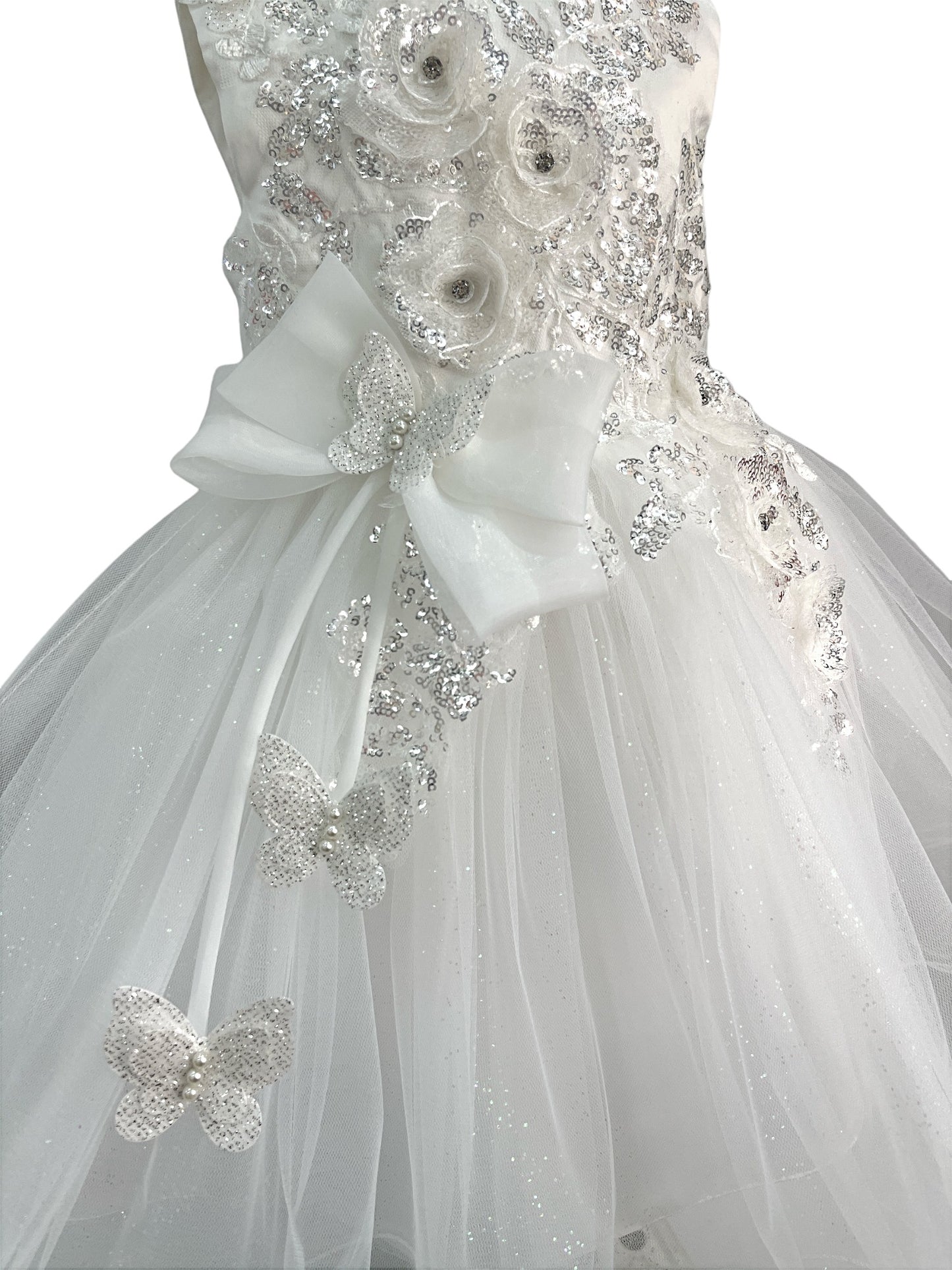 Close-up front view of white dress showing shimmering fabric and bow accent