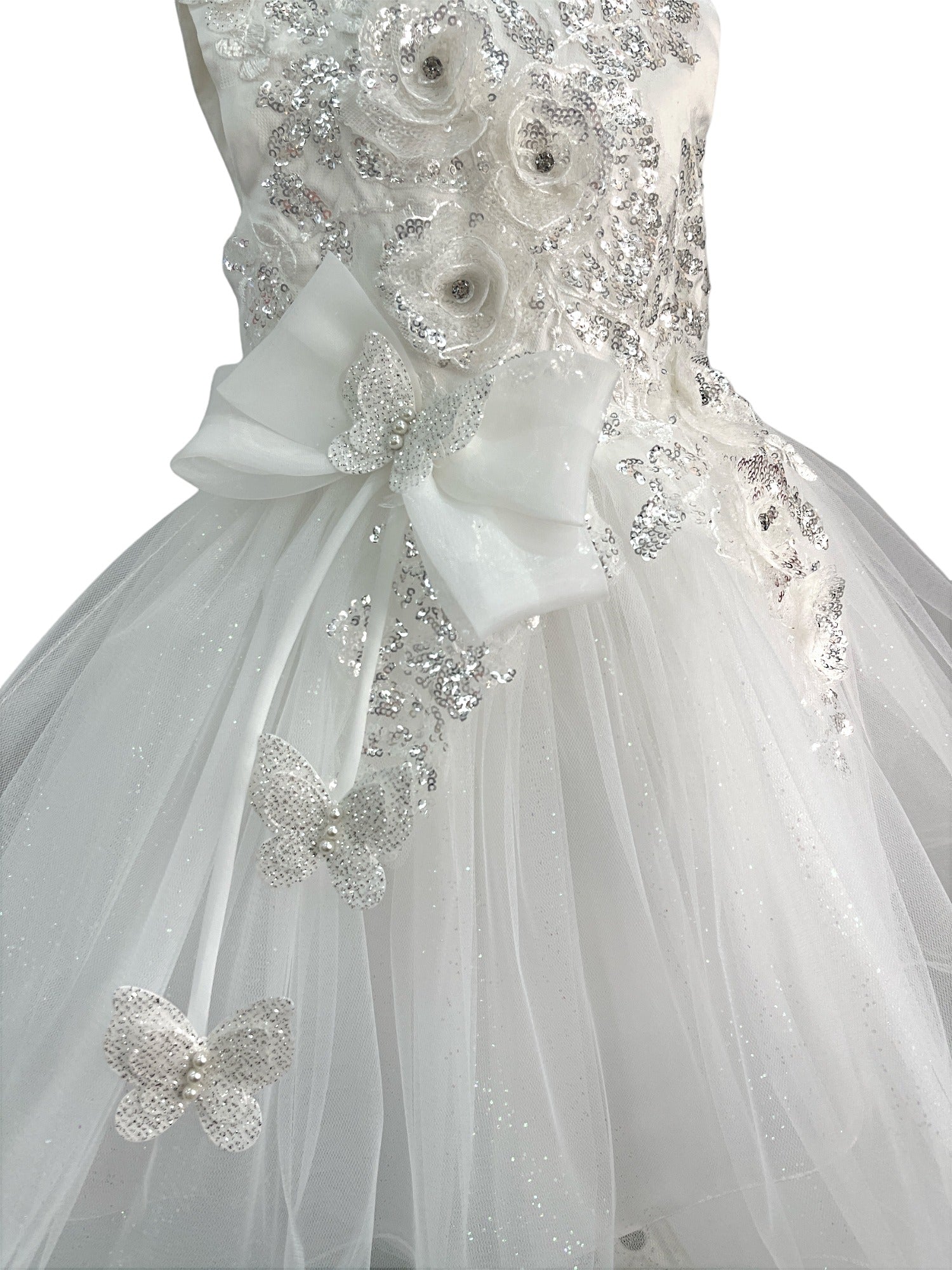 Close-up front view of white dress showing shimmering fabric and bow accent