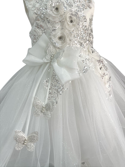 Close-up front view of white dress showing shimmering fabric and bow accent