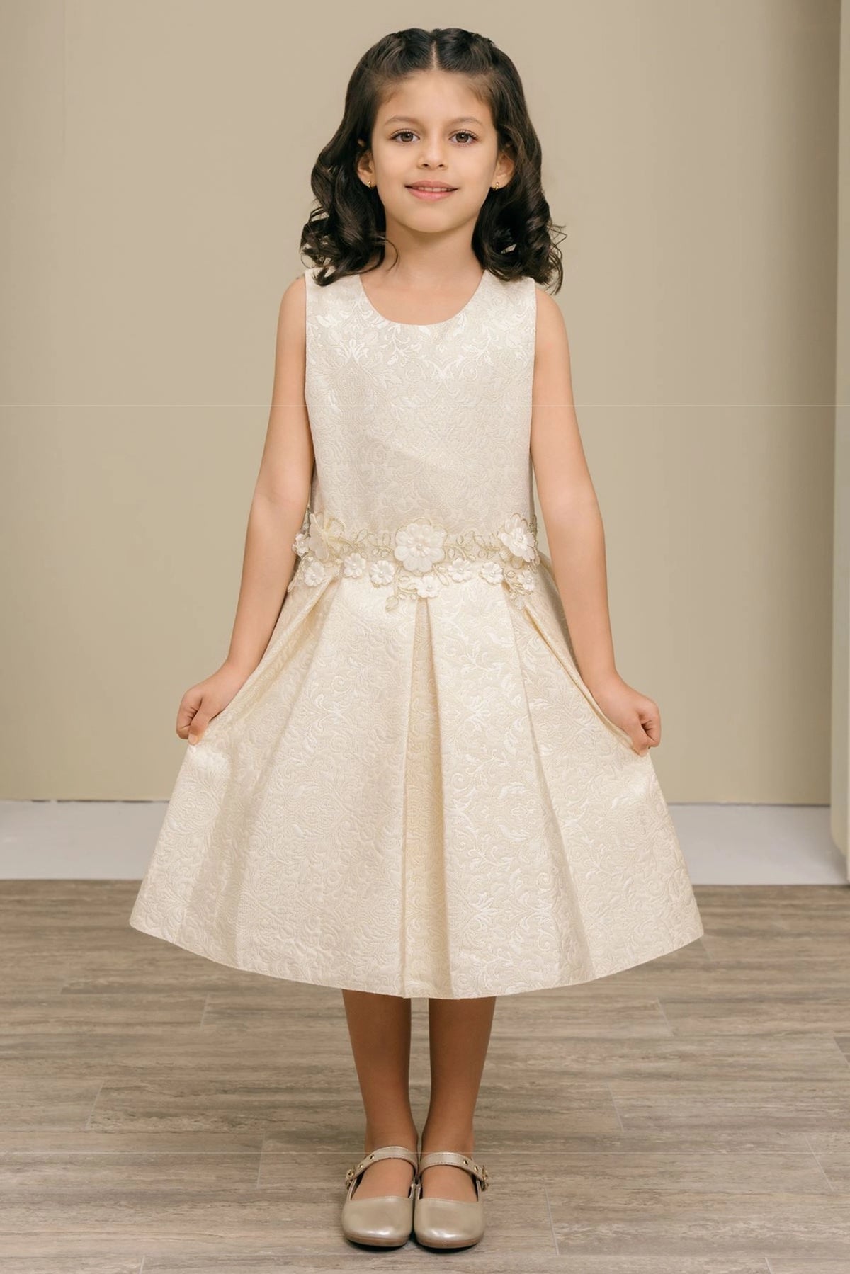 Showcasing with flowers clustered along the waist, this Ivory kids party dress displays elegant detail.