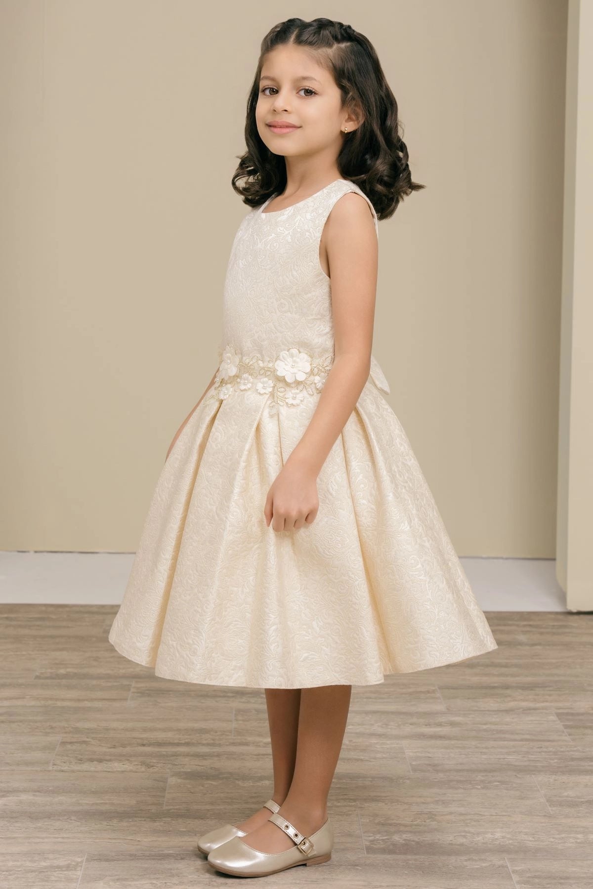 Featuring with a softly pleated skirt, this Ivory kids party dress displays elegant detail.