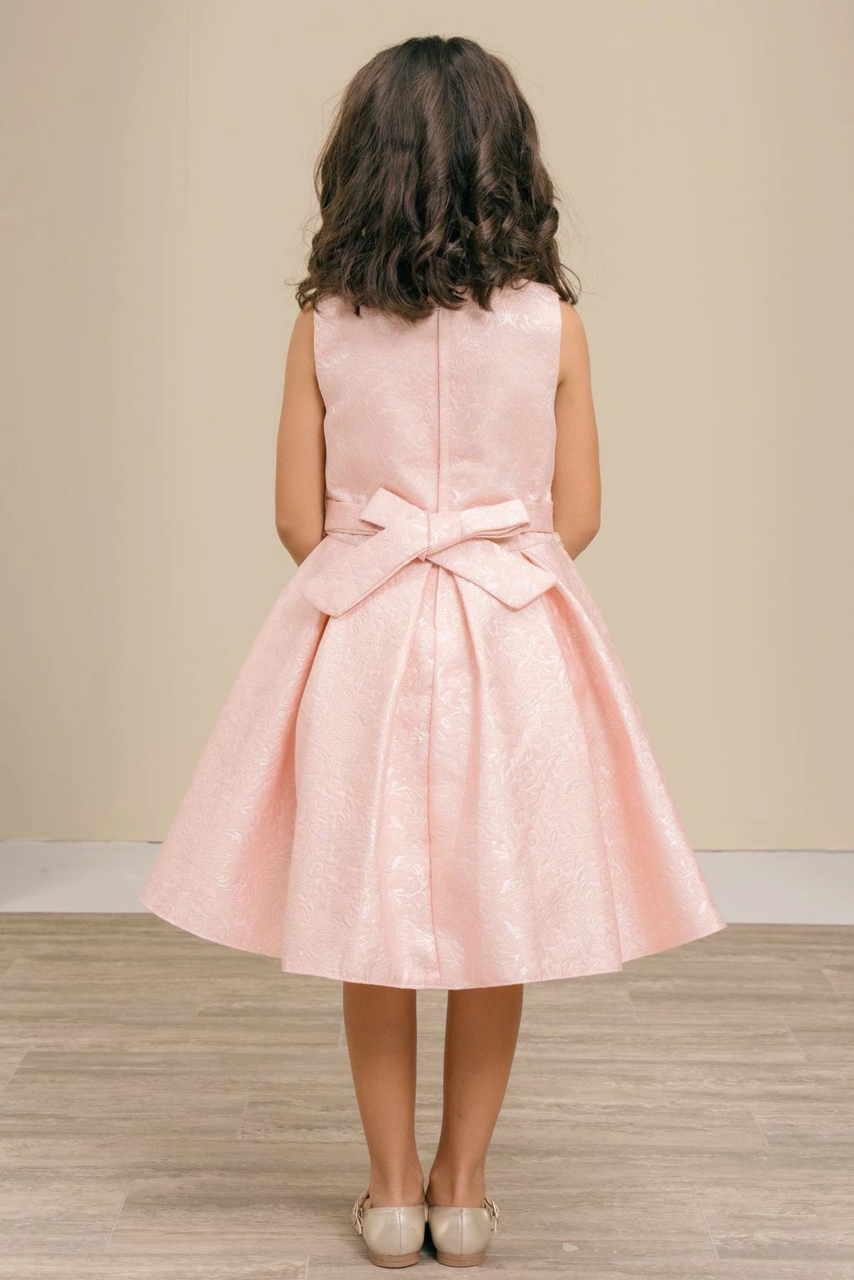 Showcasing with a large waist bow, this Pink kids party dress displays elegant detail.