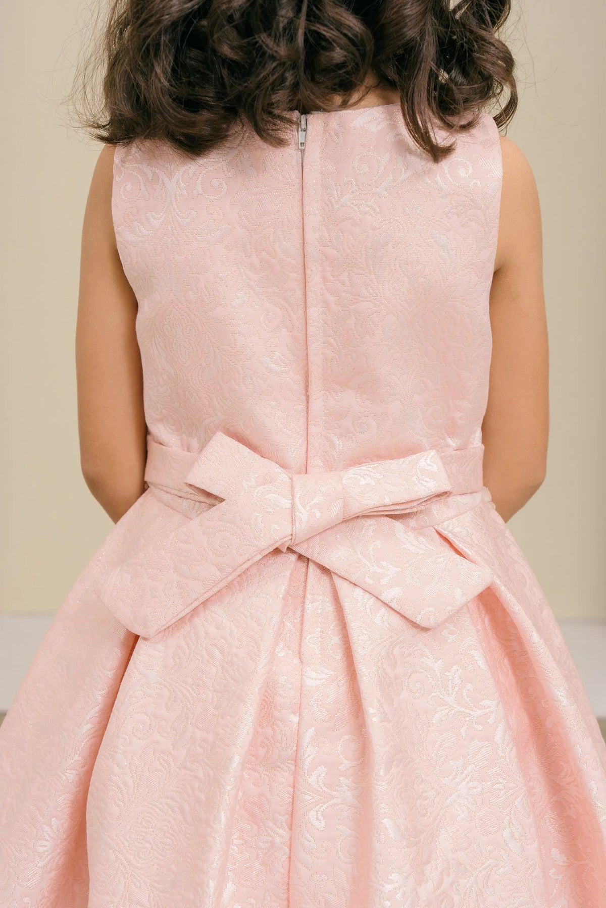 Finished details of a large waist bow distinguish the Pink kids party dress.