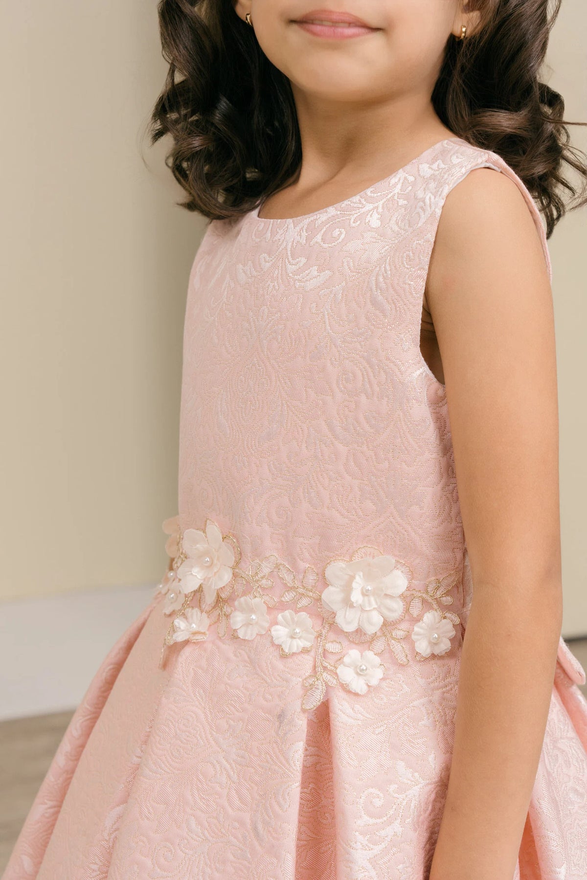 Detailed by flowers clustered along the waist, the Pink kids party dress reveals its construction.