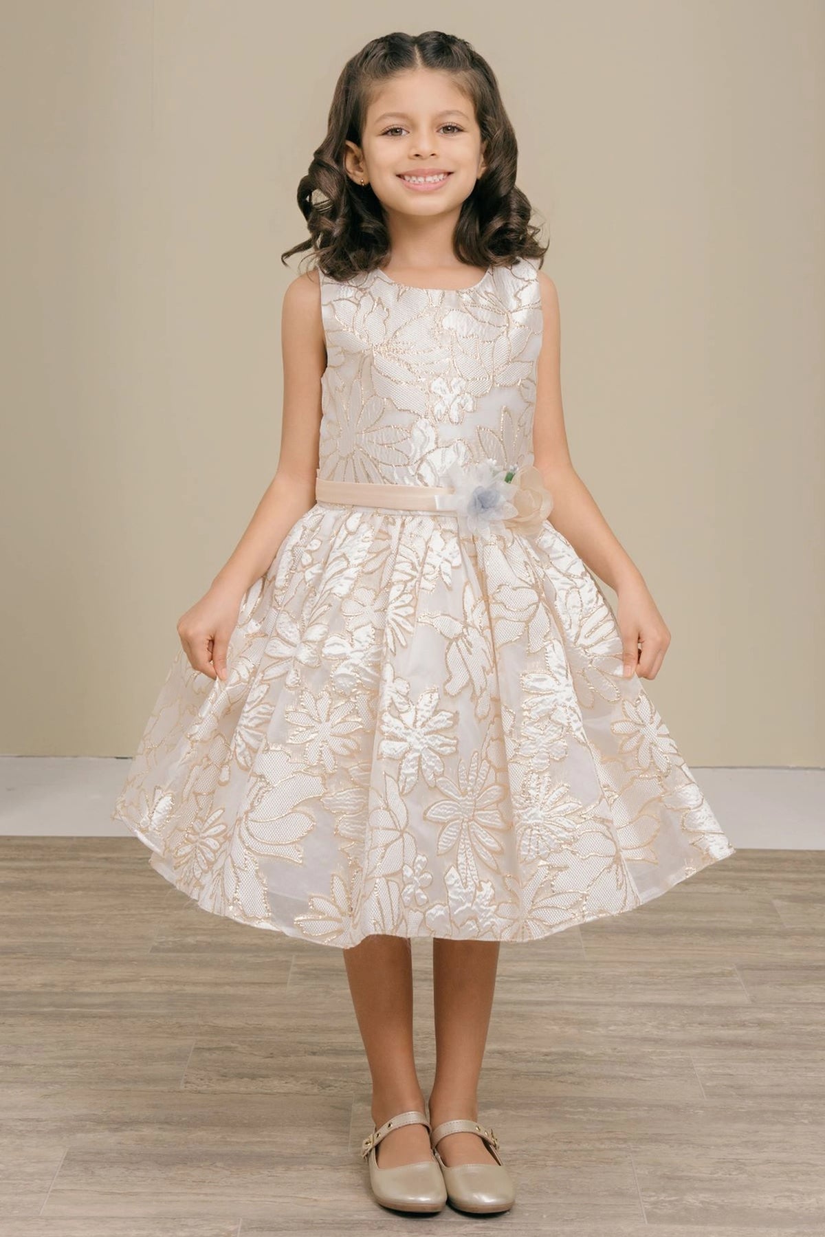 Showcasing with a decorative floral waist accent, this Champagne kids party dress displays elegant detail.