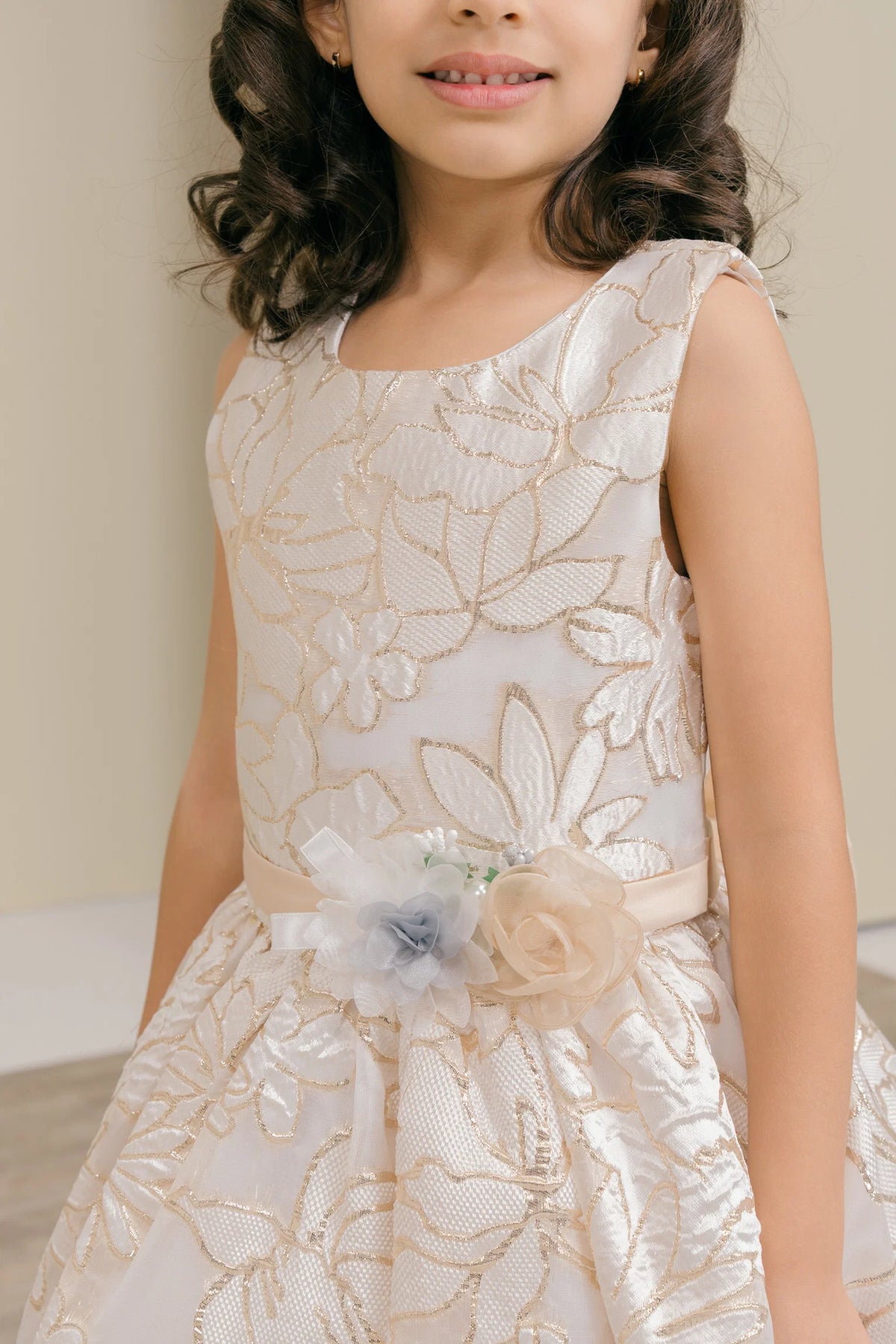Accented a decorative floral waist accent adds character to this Champagne kids party dress.