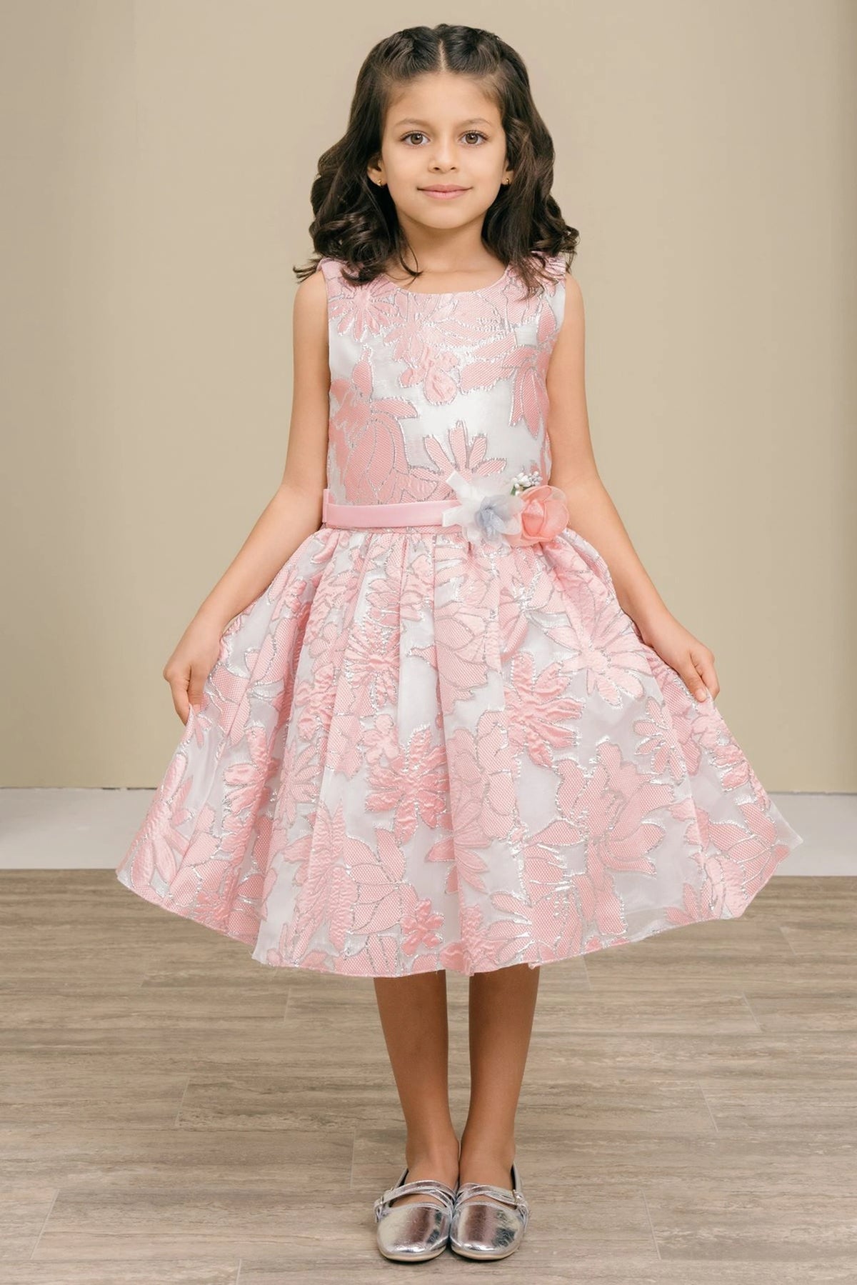 Trimmed by a decorative floral waist accent, the Pink kids party dress reveals its construction.