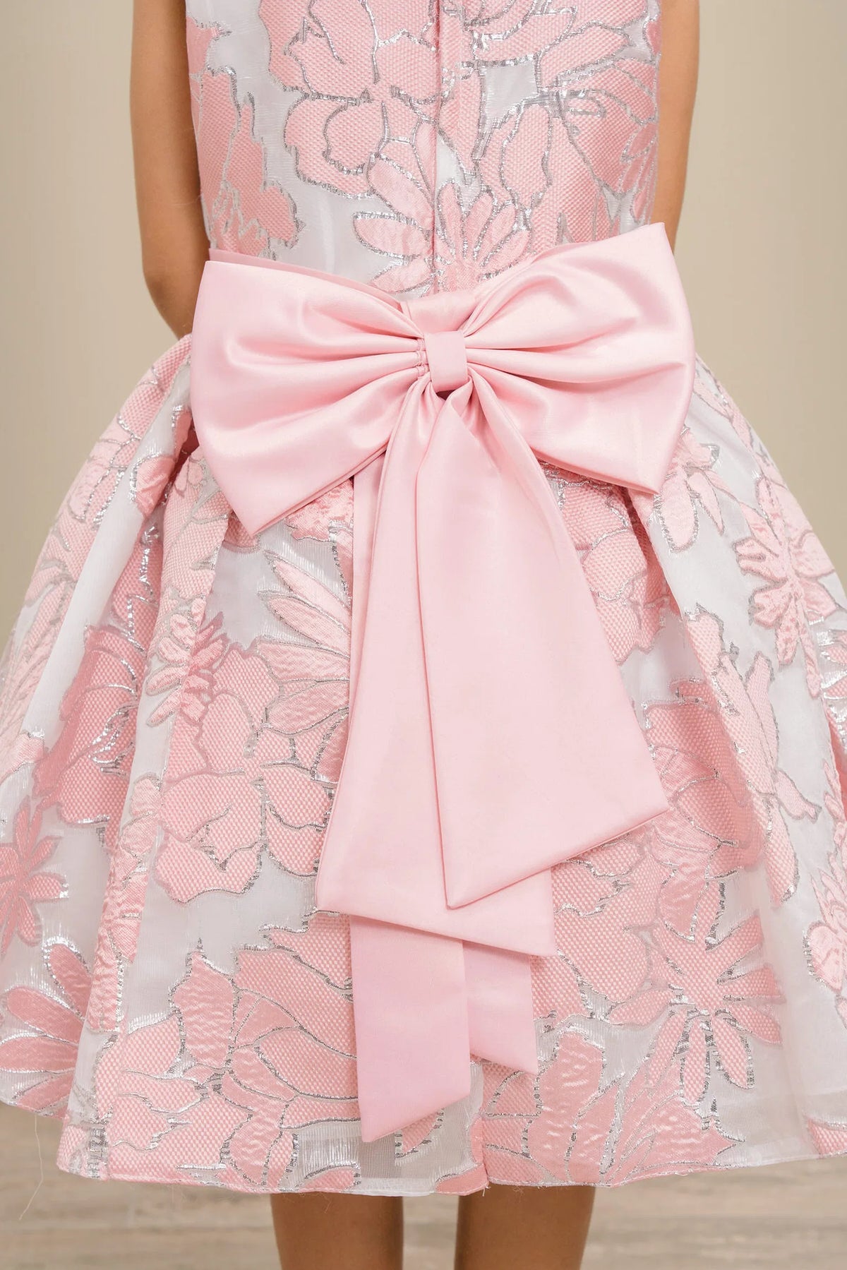 Accented a large satin bow adds character to this Pink kids party dress.