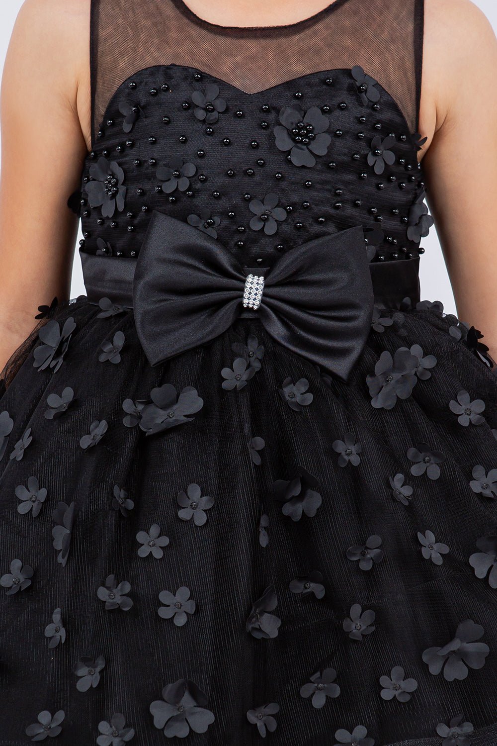 Close-up front view of black flower girl dress showing 3D floral detail and bodice texture.