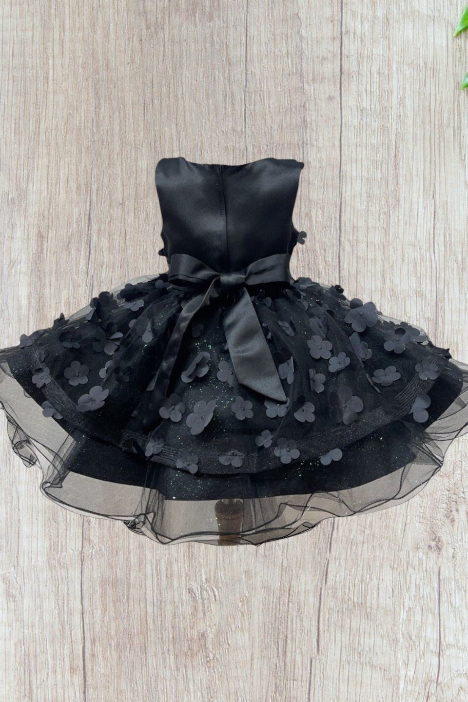 Black flower girl dress back view highlighting elegant fit and classic silhouette.