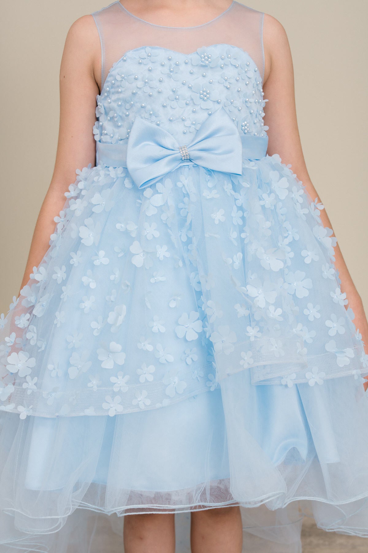 Close-up front view of blue flower girl dress showing 3D floral detail and bodice texture.